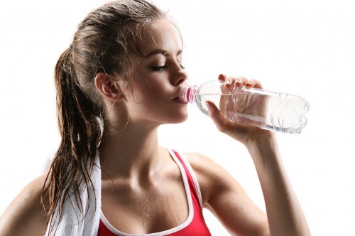 Sporty muscular woman drinking water / photo set of sporty muscular female brunette girl wearing sports clothes over white background