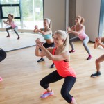 group of women making squats in gym